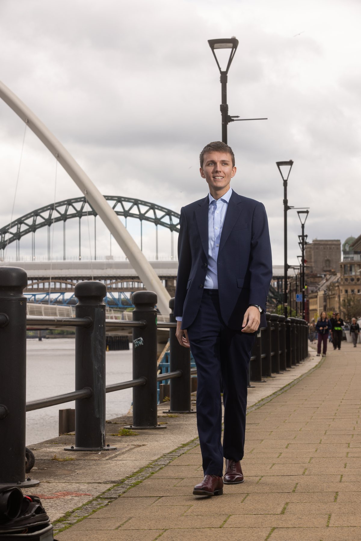 Sebastian Moore walking along Newcastle Quayside towards the Tyne Bridge